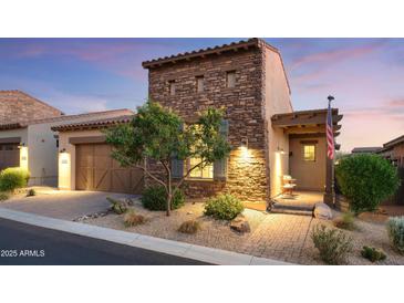 Charming stone-accented home featuring a well-manicured front yard and inviting front porch at 8691 E Eastwood Cir, Carefree, AZ 85377