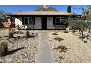 Charming single-story home featuring a covered porch and desert landscaping at 112 W Vogel Ave, Phoenix, AZ 85021
