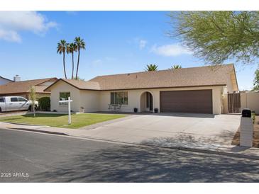 Charming single-story home featuring a well-manicured lawn, two-car garage, and a welcoming entryway at 2329 S Elm --, Mesa, AZ 85202