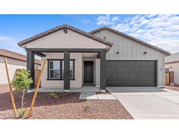 Charming single-story home featuring a covered porch, dark-colored accents, and desert-friendly landscaping at 23385 W Burton Ave, Buckeye, AZ 85326