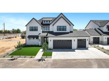 Beautiful new construction home with a three-car garage, artificial grass and modern design at 26619 S 169Th Pl, Queen Creek, AZ 85142