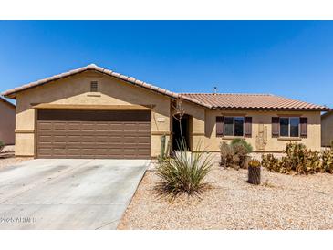 Charming single-story home featuring a two-car garage and low-maintenance desert landscaping at 40264 W Lococo St, Maricopa, AZ 85138