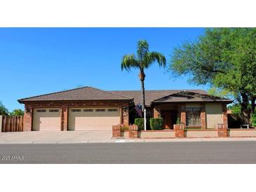 Charming single-story brick home with a three-car garage and manicured landscaping, creating great curb appeal at 6372 W Redfield Rd, Glendale, AZ 85306