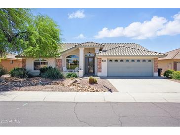 Charming single-story home features a desert landscape, covered entry, and a two-car garage at 11059 E Kilarea Ave, Mesa, AZ 85209