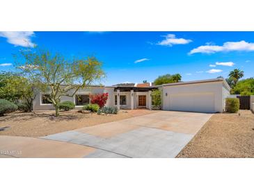 Charming single-story home with desert landscaping, a covered front patio, and an attached two-car garage at 13007 N 1St St, Phoenix, AZ 85022