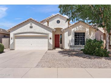 Charming single-story home with a two car garage, red door, desert landscaping and neutral colored stucco at 146 E Rock Wren Dr, San Tan Valley, AZ 85143