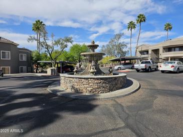 Beautiful water fountain feature in community with desert landscaping, palm trees, and covered parking at 1720 E Thunderbird Rd # 2087, Phoenix, AZ 85022