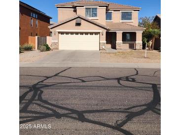 Inviting two-story home featuring a covered porch, a neutral color palette and an attached two car garage at 1810 N Mcdonald St, Casa Grande, AZ 85122