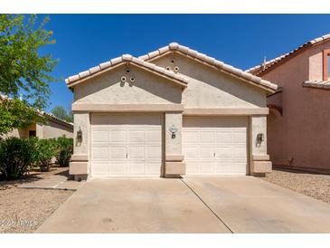 Home featuring a two-car garage, desert landscaping, and neutral color palette at 18221 N 49Th Pkwy, Glendale, AZ 85308