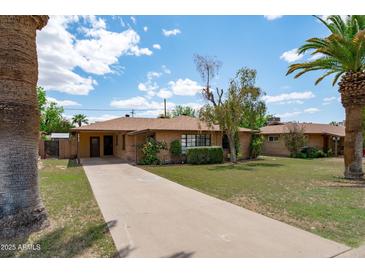 Charming single-story home with a long driveway and a well-maintained lawn at 2913 E Earll Dr, Phoenix, AZ 85016