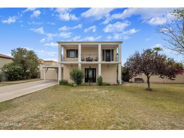 Two-story home featuring a beautiful facade with a second story balcony and well-manicured lawn at 55 E Pierson St, Phoenix, AZ 85012
