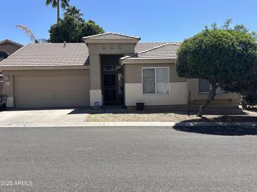 Charming single-story home with a well-maintained front yard and attached two-car garage at 6631 E Rhodes St, Mesa, AZ 85215
