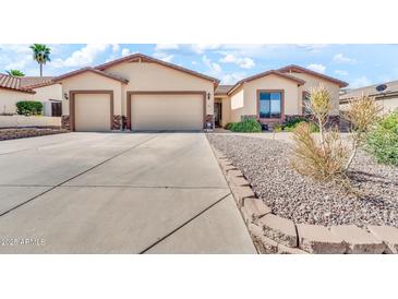 Inviting single-story home featuring a three-car garage and desert landscaping at 747 E Meadow Ln, Phoenix, AZ 85022
