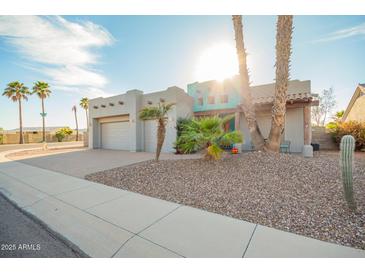Inviting single-story home featuring desert landscaping, a two-car garage, and a unique turquoise entry at 988 W Crooked Stick Dr, Casa Grande, AZ 85122