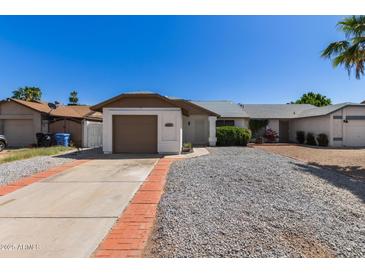 Charming single-story home with a brown garage door and low-maintenance landscaping at 1633 E Beverly Ln, Phoenix, AZ 85022