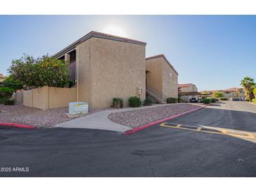 Complex featuring covered parking, desert landscaping and colorful buildings at 1730 W Emelita Ave # 2027, Mesa, AZ 85202