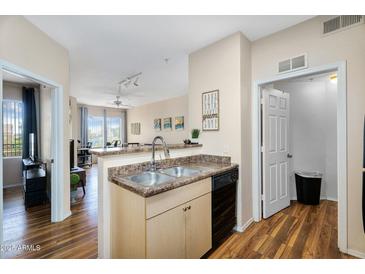 Open-concept kitchen with stainless steel sink and a view into the living room at 18416 N Cave Creek Rd # 3034, Phoenix, AZ 85032