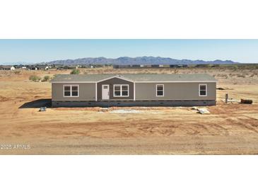 Single-story home featuring a white front door, neutral siding, and mountain views at 23117 W Duane Ln, Wittmann, AZ 85361
