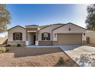 Charming single-story home featuring a two-car garage, desert landscaping, and a welcoming entryway at 30003 W Rockmount Ave, Buckeye, AZ 85396