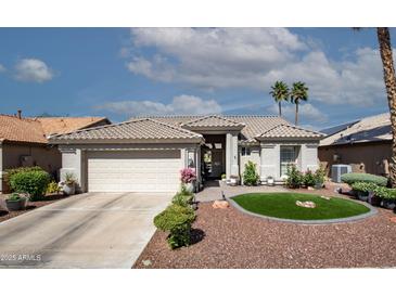 Charming single-story home with a well-manicured front yard and a two-car garage in a sunny locale at 3070 N 148Th Dr, Goodyear, AZ 85395