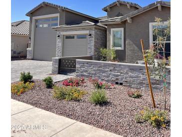 Beautifully landscaped front yard with stone accents and a paved driveway offers great curb appeal at 11074 W Tonto St, Avondale, AZ 85323