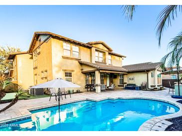 Inviting backyard pool with umbrella and outdoor seating perfect for entertaining guests at 13686 N 151St Dr, Surprise, AZ 85379