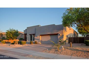 Contemporary home exterior with desert landscaping, a two-car garage, and stucco finish at 14045 E Geronimo Rd, Scottsdale, AZ 85259