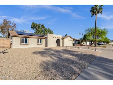 Charming single-story home with desert landscaping, solar panels, and a unique arched entryway at 14215 N 36Th Way, Phoenix, AZ 85032