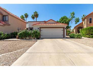 Charming home featuring a red tile roof, two-car garage, and drought-resistant landscaping at 1425 E Commerce Ave, Gilbert, AZ 85234