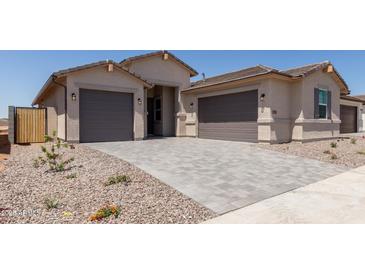 Charming new home showcasing a three-car garage and beautiful desert landscaping at 25324 N 131St Dr, Peoria, AZ 85383