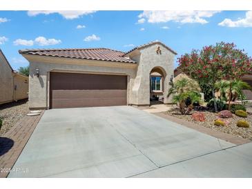 Charming home featuring a tile roof, desert landscaping, and a spacious driveway leading to a two-car garage at 26456 W Cat Balue Dr, Buckeye, AZ 85396