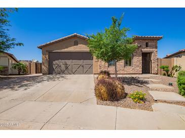 Charming single-story home with a well-manicured front yard, desert landscaping, and a three-car garage at 29703 N 70Th Ave, Peoria, AZ 85383