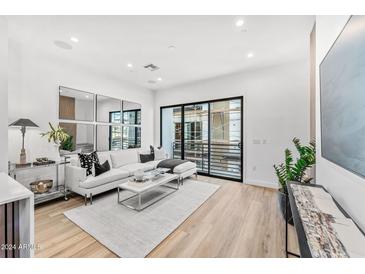 Bright living room featuring a white couch, sliding glass doors, and modern decor at 4220 N 32Nd St # 7, Phoenix, AZ 85018
