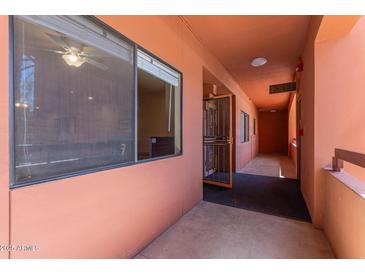 Condo hallway featuring an exit sign and peach colored paint and doors at 4303 E Cactus Rd # 202, Phoenix, AZ 85032
