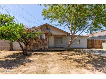 Charming single-story home with a stone facade, light siding and drought tolerant landscaping at 452 S Horne --, Mesa, AZ 85204