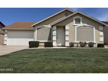 Charming single-story home with manicured lawn and white trimmed windows and door at 6335 E Brown Rd # 1065, Mesa, AZ 85205
