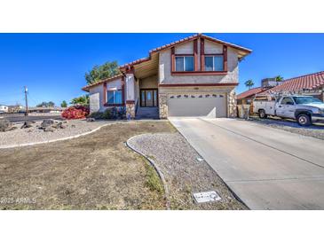 Charming home with a two-car garage, covered front entry, and low-maintenance landscaping at 7844 W Jenan Dr, Peoria, AZ 85345