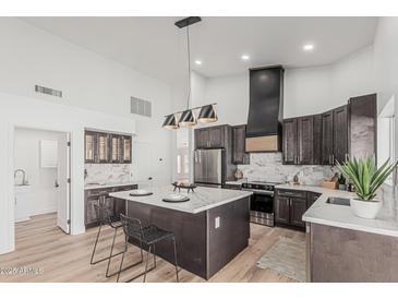 Modern kitchen featuring stainless steel appliances, a large island, and stylish pendant lighting at 862 W Rawhide Ave, Gilbert, AZ 85233