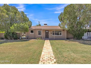 Charming single-story home with a well-maintained lawn and inviting brick pathway at 101 W 8Th Pl, Mesa, AZ 85201