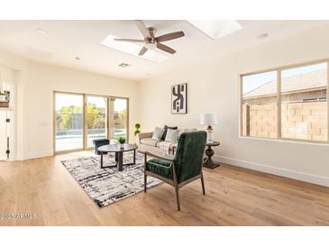 Bright living room with skylight, wood floors, and sliding glass doors to the backyard at 10276 E Meandering Trail Ln, Gold Canyon, AZ 85118