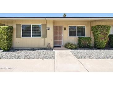 Inviting front entrance with security door, manicured shrubbery and gravel landscaping at 10921 W Santa Fe Dr, Sun City, AZ 85351