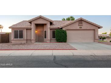 Charming single-story home featuring a neutral stucco exterior, tile roof, and well-maintained landscaping at 1220 S Wagon Wheel Dr, Chandler, AZ 85286