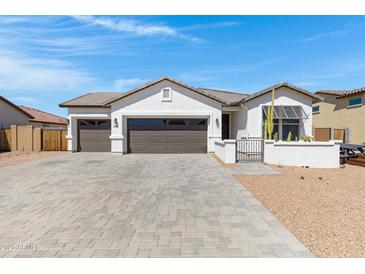 Charming single-story home showcasing a three-car garage and well-manicured desert landscaping at 17084 N Palo Pino St, Maricopa, AZ 85138