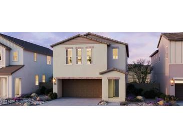 Charming two-story home with a two car garage and landscaped front yard at twilight at 2476 W Rowel Rd, Phoenix, AZ 85085