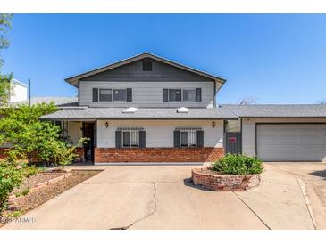 Traditional two-story house with a brick accent wall and mature landscaping in the front yard and wide driveway at 3201 W Evans Dr, Phoenix, AZ 85053