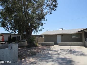Charming single-story home featuring mature tree and concrete driveway, providing ample parking space at 4624 S 19Th Ave, Phoenix, AZ 85041