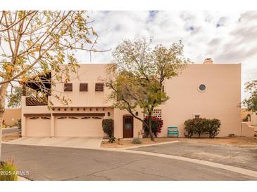 Charming two-story home boasts desert landscaping, a circular window, and a three-car garage at 6411 S River Dr # 28, Tempe, AZ 85283