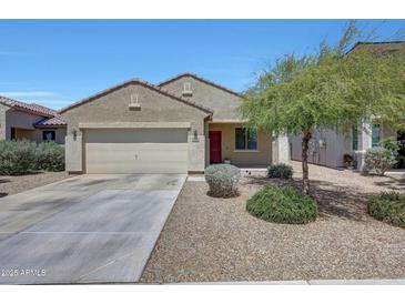 Charming single-story home featuring a two-car garage, desert landscaping, and a vibrant red front door at 7236 W Townley Ave, Peoria, AZ 85345