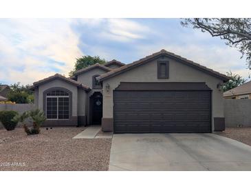 Charming single-story home with a well-manicured front yard and a two-car garage at 14968 N 134Th Ln, Surprise, AZ 85379