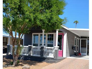 Charming home featuring a covered front porch and a vibrant pink front door at 201 S Greenfield Rd # 215, Mesa, AZ 85206